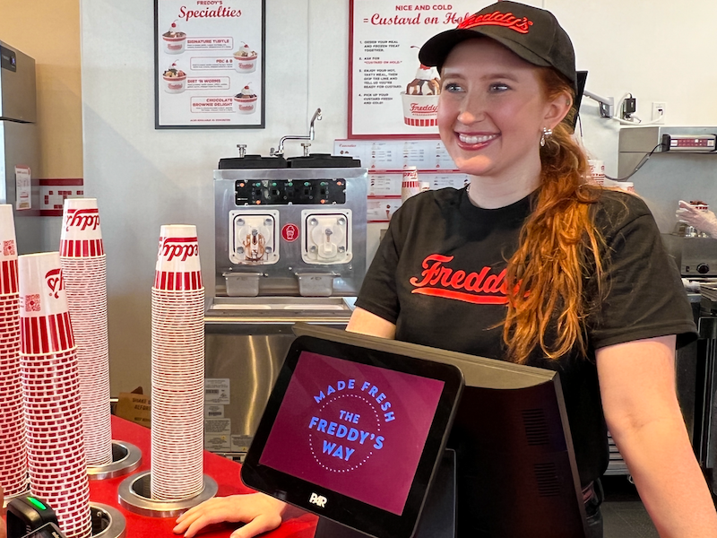 Freddy's team member smiling behind the front counter