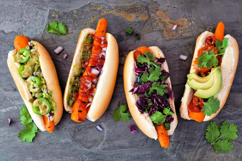 4 hot dogs in buns with different toppings