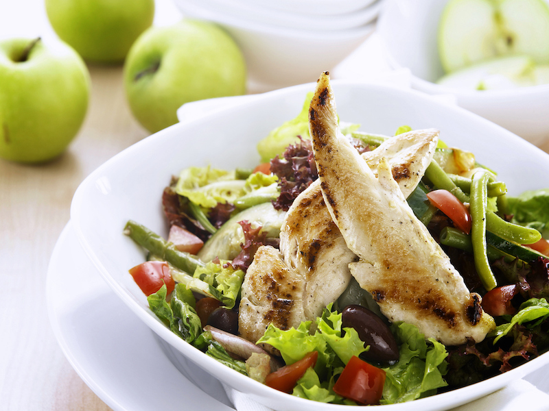 Fresh salad with grilled chicken, tomatoes, green beans, and olives