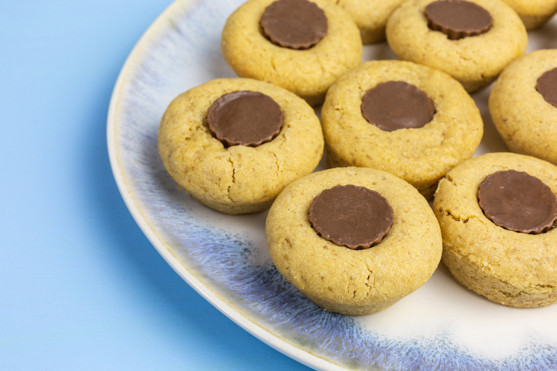 Peanut butter cookies topped with mini peanut butter cups on a plate
