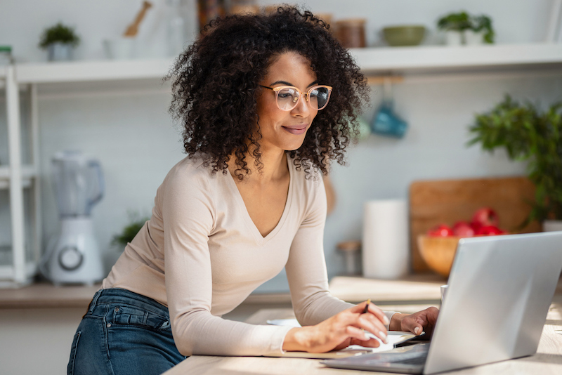 Person using a laptop at a kitchen counter