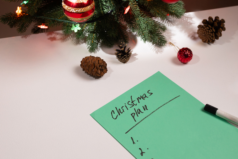 Holiday planning checklist on a desk with Christmas decorations