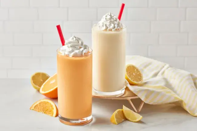 Freddy’s Orange Creamsicle and Lemonade Frosts with whipped cream and fruit slices