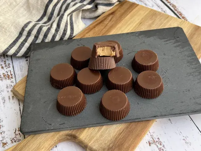 Assorted peanut butter cups arranged on a slate board