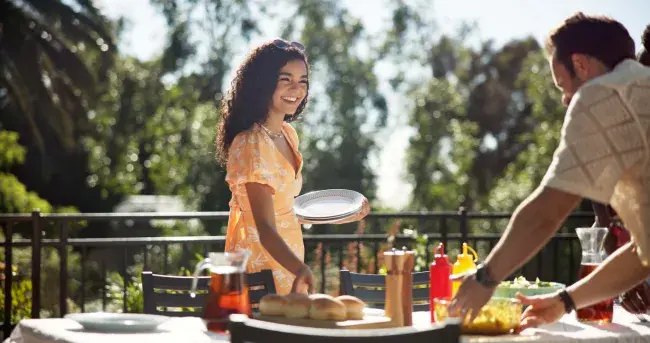 Friends setting table for cookout outdoors