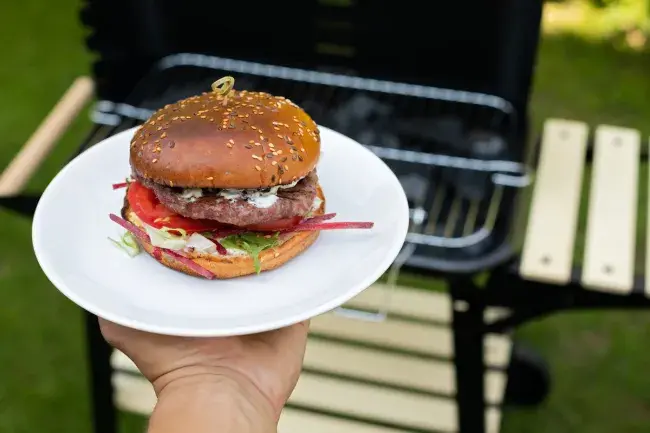 Burger on plate by outdoor grill