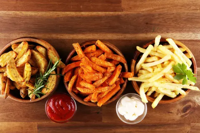 Assorted fries in bowls with dipping sauces