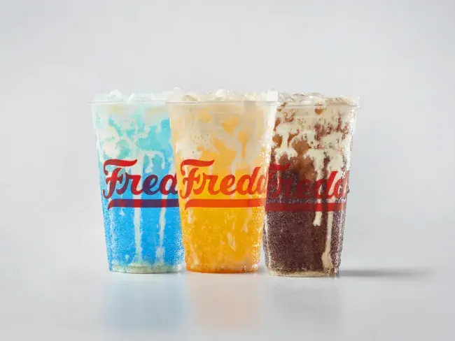 Trio of Freddy's Bevies. From left to right: Blue Rizzberry Custard Cream Soda, Golden Hour Orange Custard Cream Soda, and Coco Loco Custard Cream Soda.