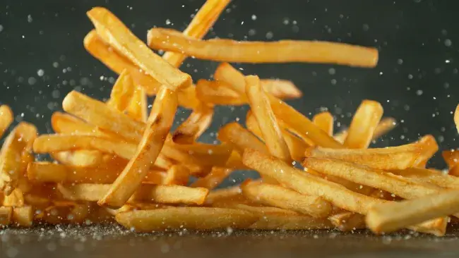 Shoestring French fries tossed in seasoning mid-air