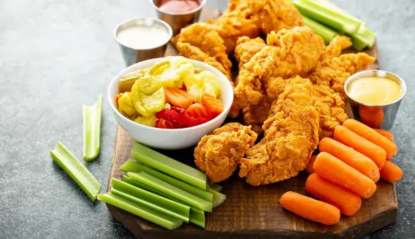 Fried chicken tenders with celery, carrots, pickled vegetables, and dipping sauces