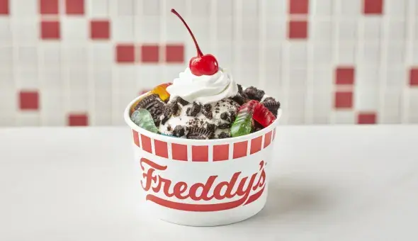 Freddy’s Dirt &amp; Worms kids sundae with crushed OREO® cookies, gummy worms, whipped cream, and a cherry
