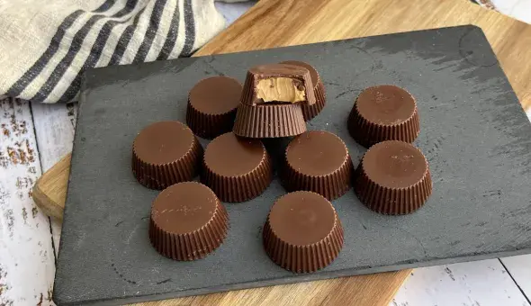 Assorted peanut butter cups arranged on a slate board