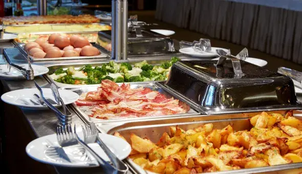 Brunch buffet with eggs, bacon, roasted potatoes, and vegetables