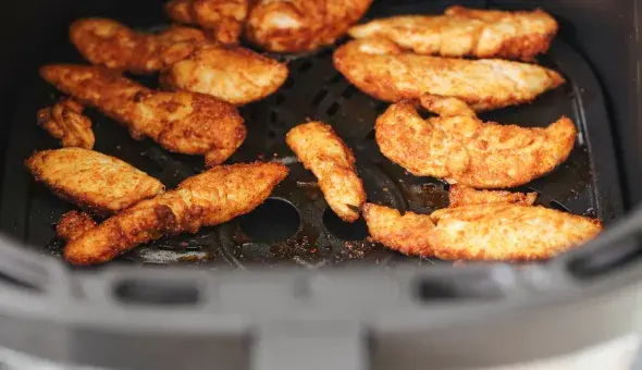 Chicken tenders cooking in an air fryer