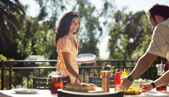 Friends setting table for cookout outdoors
