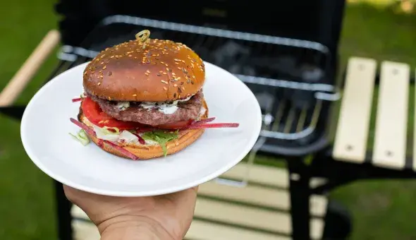 Burger on plate by outdoor grill