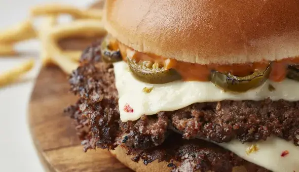 Close-up of Freddy’s Jalapeno Pepper Jack Steakburger with melted cheese and jalapenos