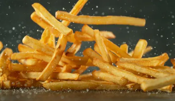 Shoestring French fries tossed in seasoning mid-air