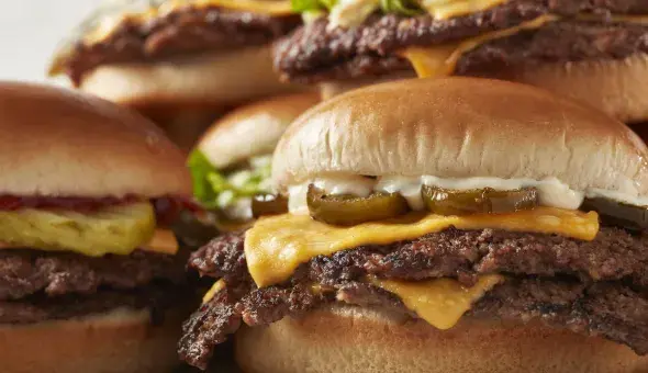 Assortment of steakburgers with melted cheese and assorted toppings