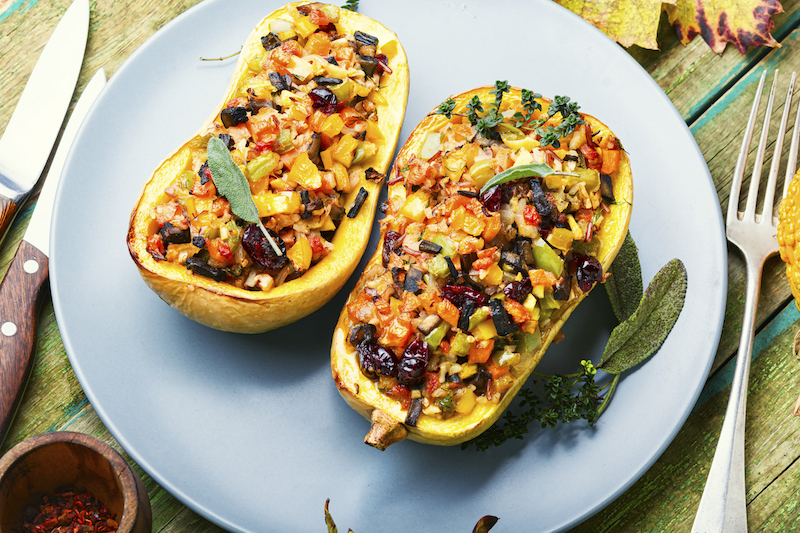 Roasted butternut squash halves filled with colorful vegetable stuffing
