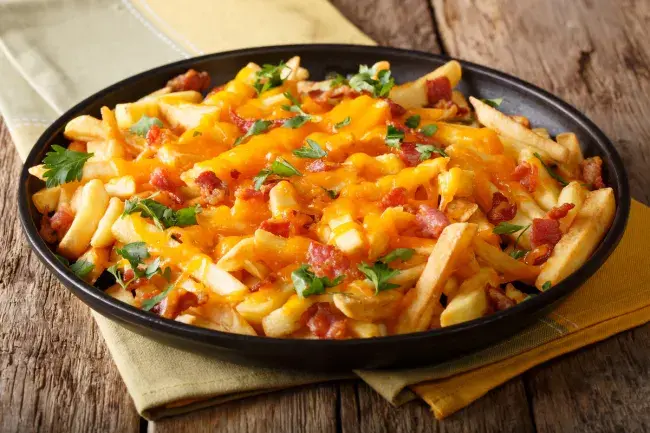Cheese fries with bacon in a skillet