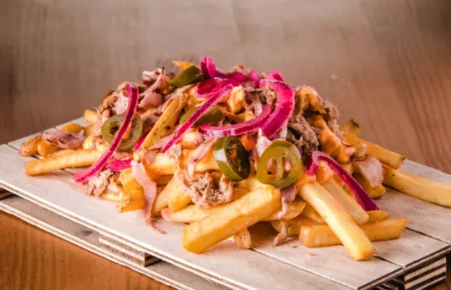 Loaded fries topped with pulled pork, jalapenos, and pickled onions